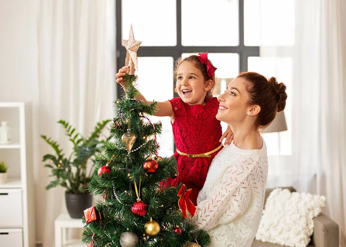 Single mom decorating christmas tree with child