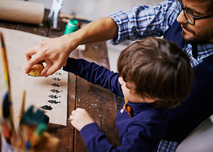 father and son doing holiday crafts together