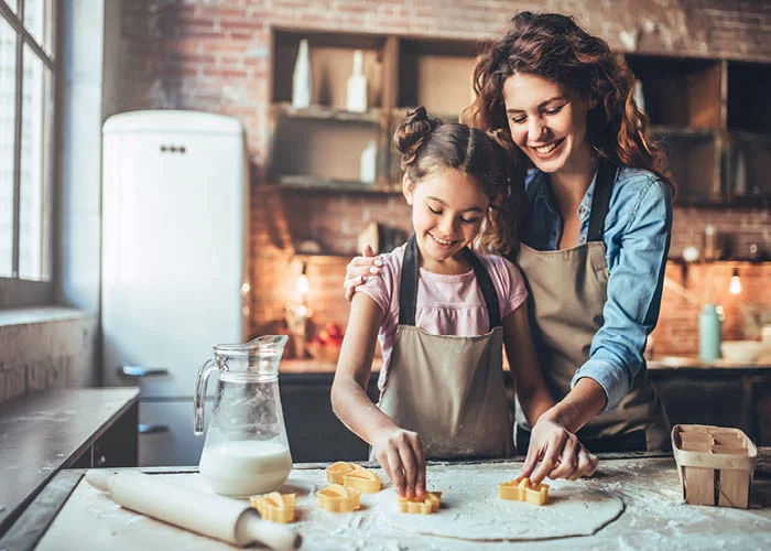 mom with girl baking cookies